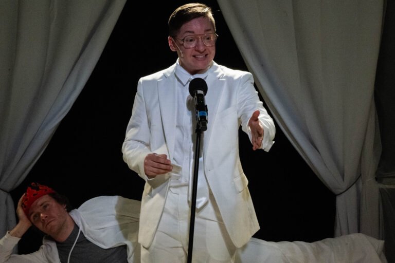 As Bishop Mansfield in "...Stunning Death". KP is in a white suit at a standing microphone. (Vivian Hoffman)